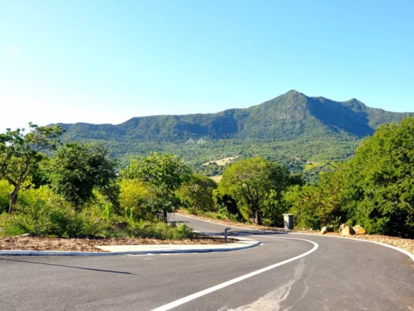 Route sinueuse menant à des montagnes verdoyantes à l'île Maurice.
