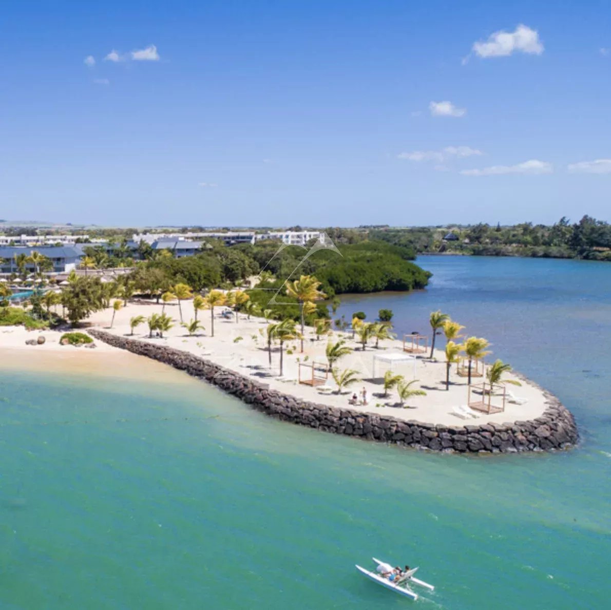 Beach and lagoon with palm trees and a kayak at Haute Rive, Mauritius.
