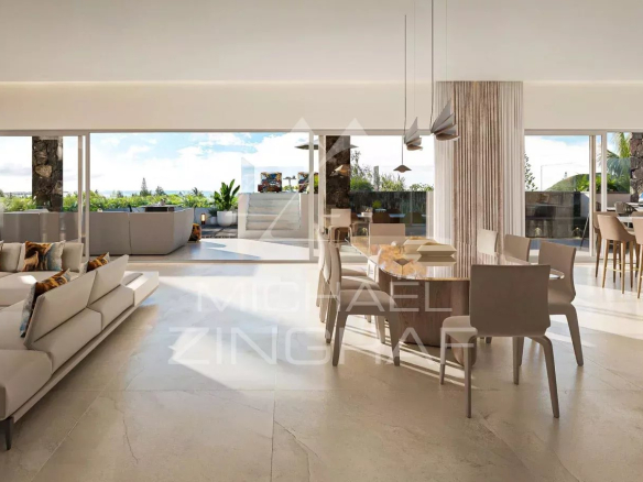 Intérieur d'un penthouse moderne avec vue sur la mer à Pereybère, espace de vie lumineux et mobilier contemporain.