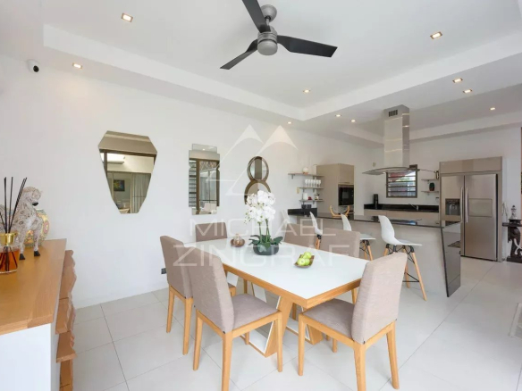 Intérieur d'une villa contemporaine avec salle à manger et cuisine ouverte.