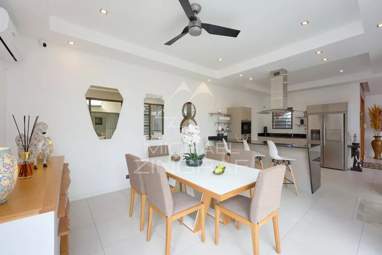 Intérieur d'une villa contemporaine avec salle à manger et cuisine ouverte.
