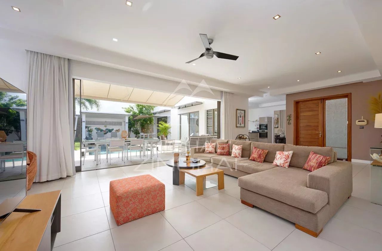 Intérieur d'une villa contemporaine avec salon spacieux et accès à la piscine.