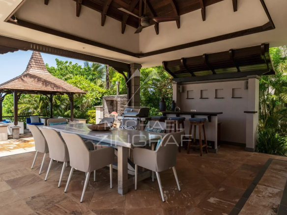 Outdoor terrace of a villa with barbecue and dining area, overlooking the surrounding nature.