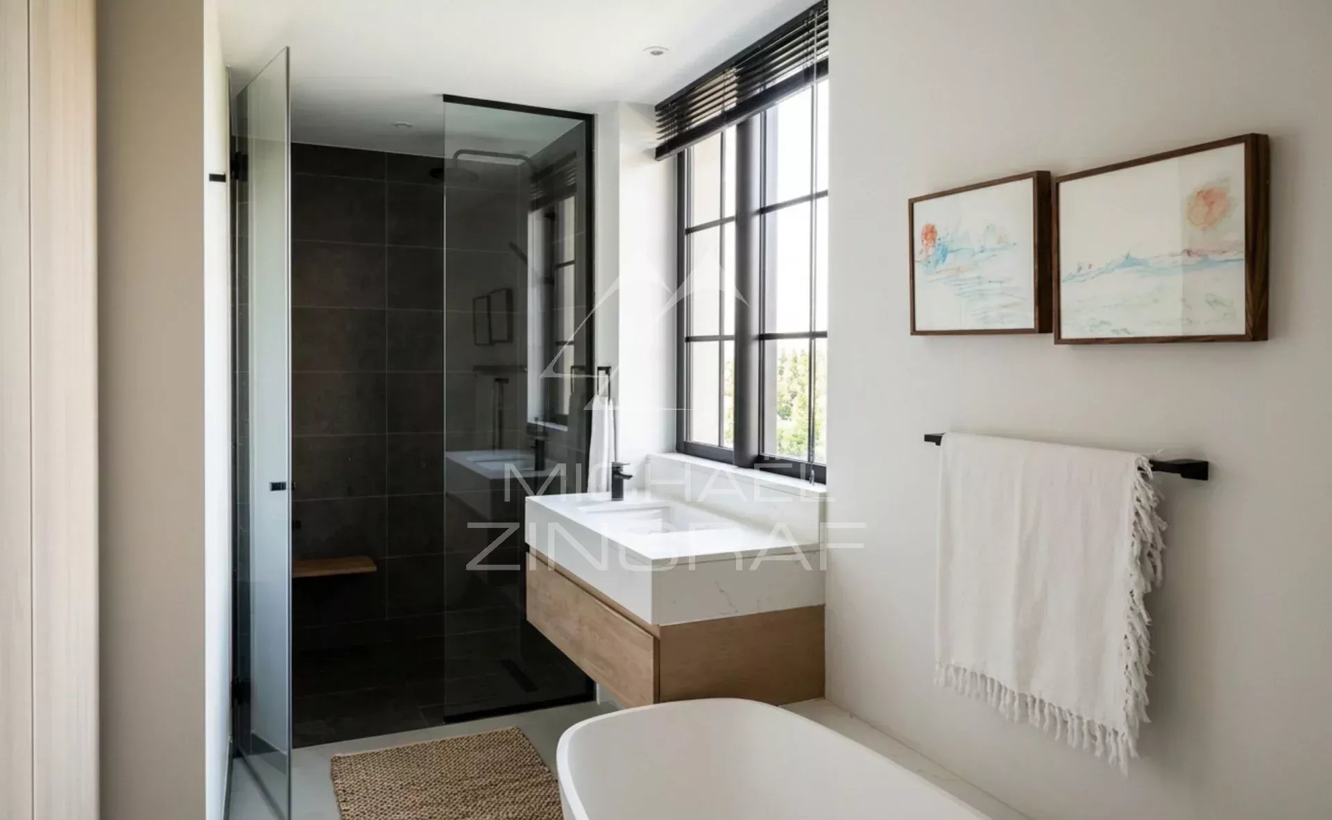 Bathroom in the penthouse at Pointe aux Canonniers Modern bathroom with glass shower and bathtub, minimalist decor.
