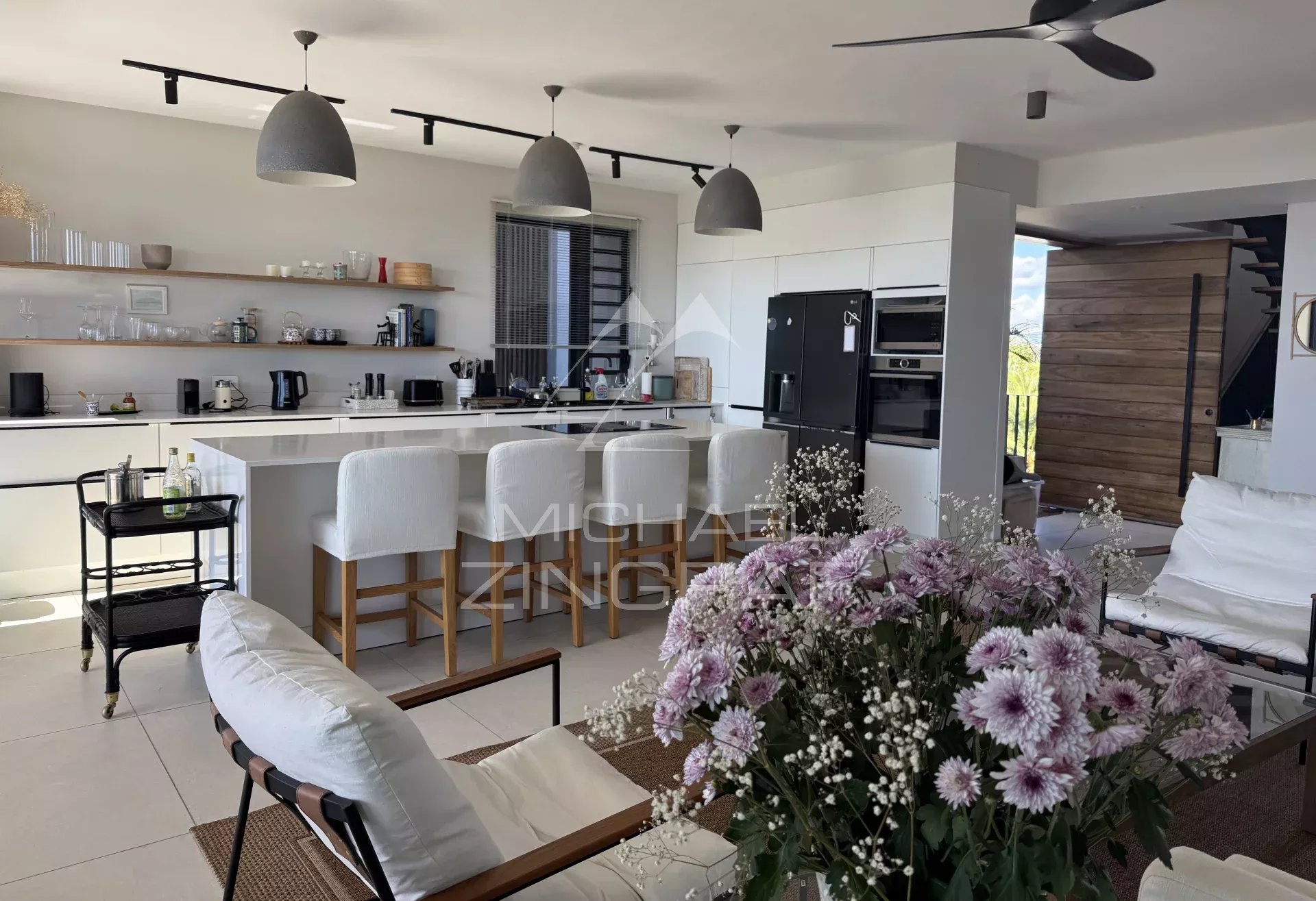 Modern penthouse in Pointe aux Canonniers Interior of a modern penthouse with open kitchen and living room, decorated with flowers.