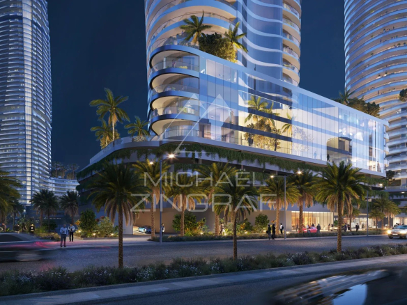Vue d'un bâtiment moderne à Dubaï, illuminé la nuit, avec des palmiers en premier plan.