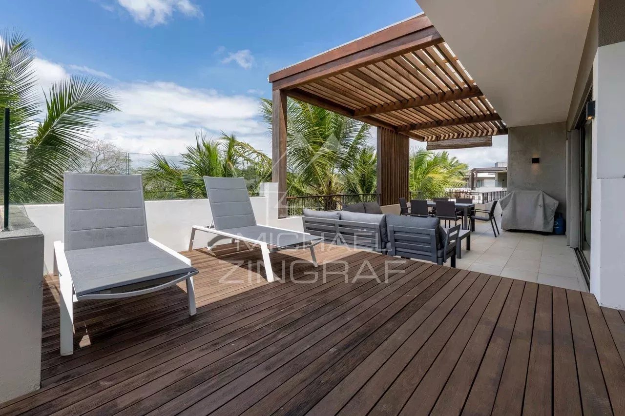 Penthouse terrace in Mont Choisy Penthouse terrace with sun loungers and outdoor furniture, surrounded by greenery.
