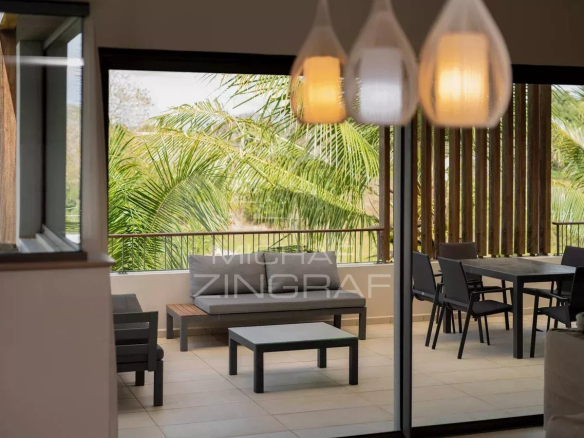 Interior of a penthouse with views of greenery, modern furniture and natural light.