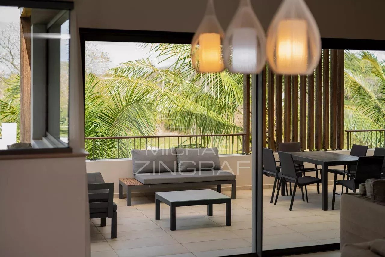 Contemporary penthouse in Mont Choisy Interior of a penthouse with views of greenery, modern furniture and natural light.