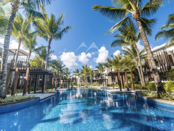 Swimming pool surrounded by palm trees in a contemporary residential complex in Mont Choisy, Grand Baie.