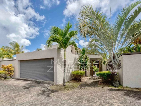 Villa moderne avec garage et jardin à Grand Baie, entourée de palmiers.
