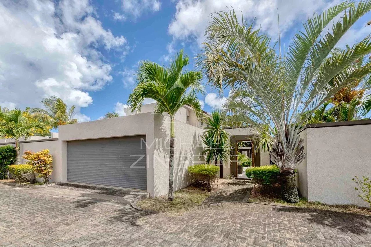 Villa moderne avec garage et jardin à Grand Baie, entourée de palmiers.
