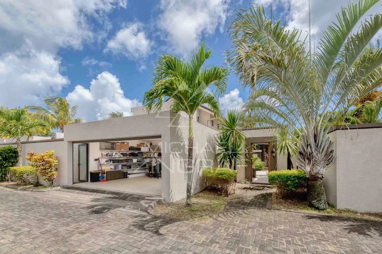 Villa moderne avec jardin à Grand Baie, entourée de palmiers et d'un espace extérieur.