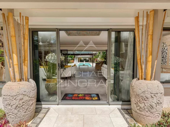 Entrée d'une villa moderne avec décoration élégante et vue sur la piscine.