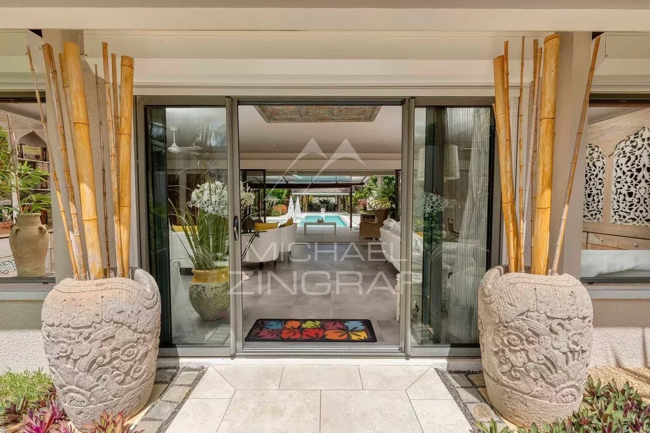 Entrée d'une villa moderne avec décoration élégante et vue sur la piscine.