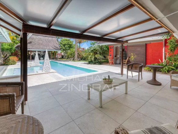 Terrasse d'une villa avec piscine à Grand Baie, entourée de verdure.