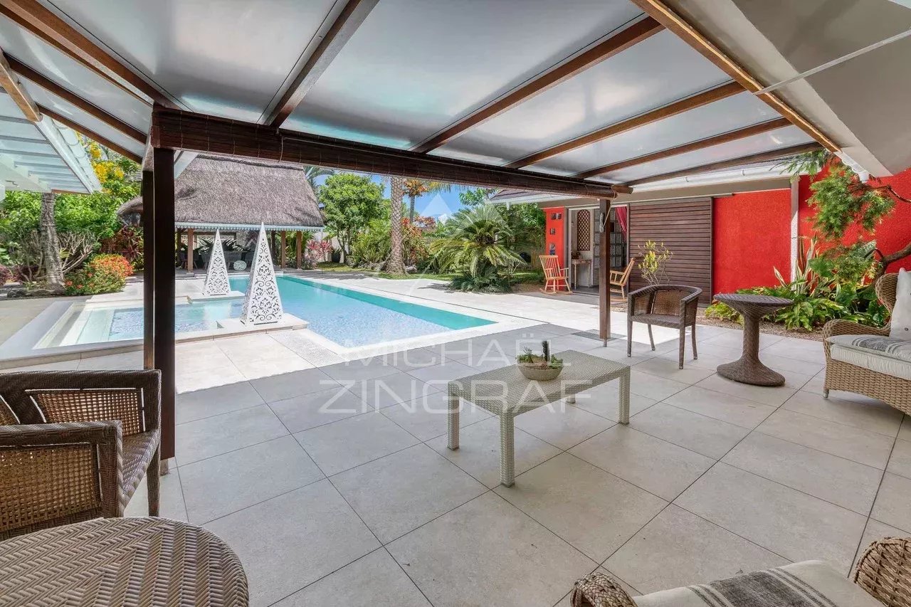 Terrasse d'une villa avec piscine à Grand Baie, entourée de verdure.