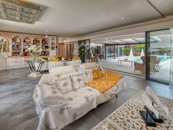 Intérieur d'une villa moderne avec salon spacieux et accès à la piscine.