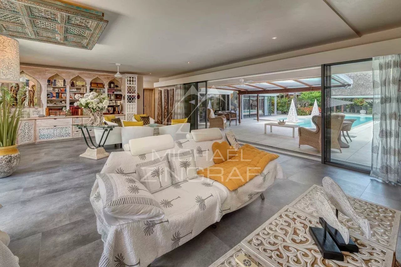 Intérieur d'une villa moderne avec salon spacieux et accès à la piscine.