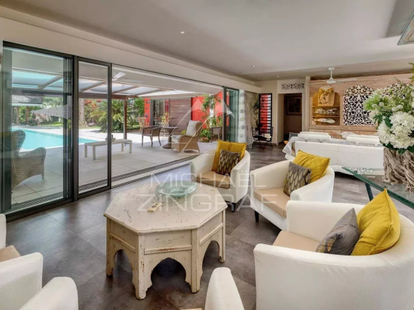 Intérieur d'une villa moderne avec salon lumineux et accès à la piscine.