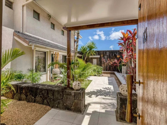 Entrée d'une villa moderne avec jardin à Grand Baie, entourée de plantes tropicales.
