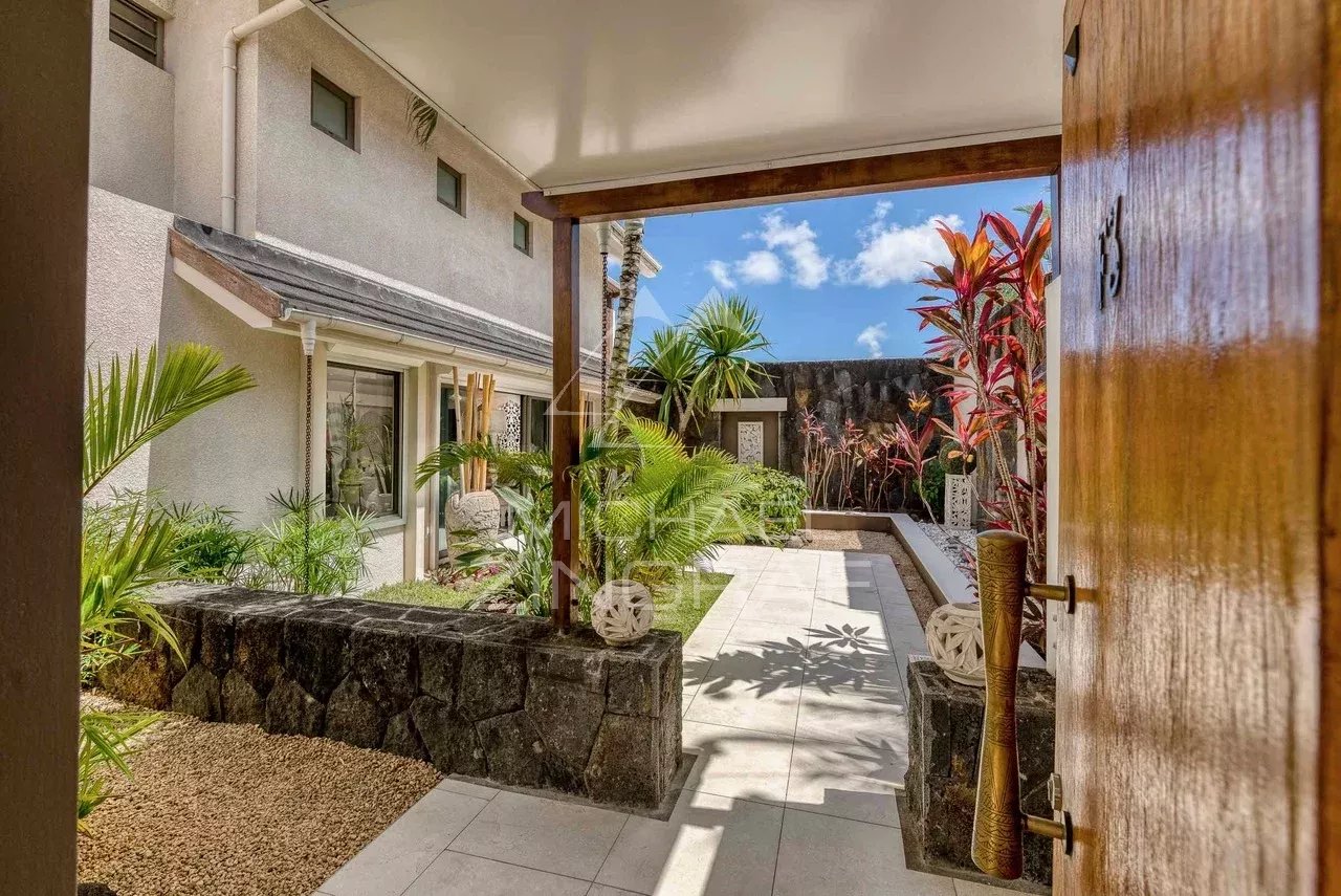 Entrée d'une villa moderne avec jardin à Grand Baie, entourée de plantes tropicales.