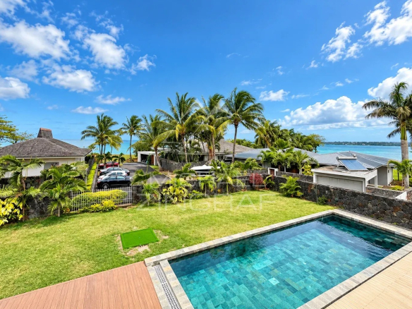 Vue d'une villa avec piscine et jardin, entourée de palmiers et d'autres résidences, à Vieux Grand Port.