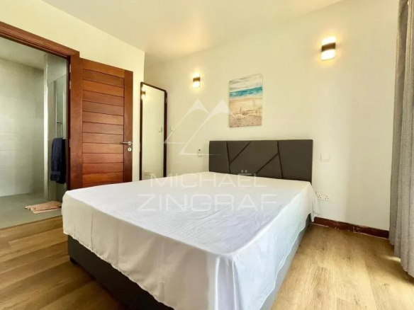 Chambre d'une villa élégante avec lit double et salle de bain attenante à Vieux Grand Port.