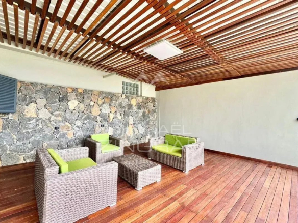 Terrasse en bois avec mobilier en rotin dans une villa élégante à Vieux Grand Port.