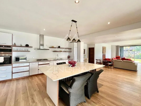 Intérieur d'une villa moderne avec cuisine ouverte et salon lumineux.