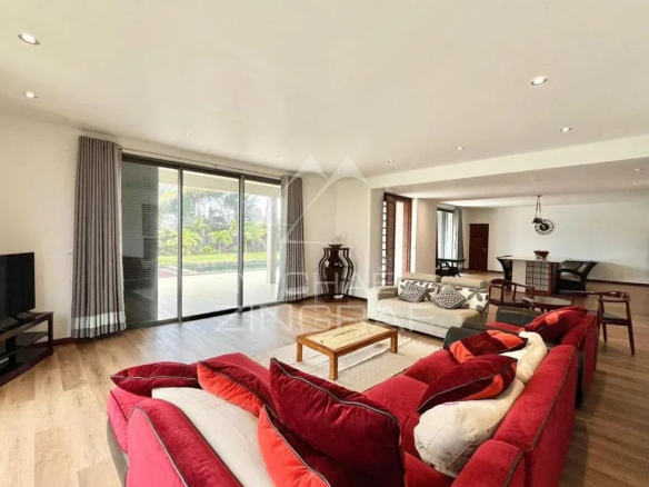 Intérieur d'une villa élégante avec salon spacieux et lumineux, vue sur le jardin.
