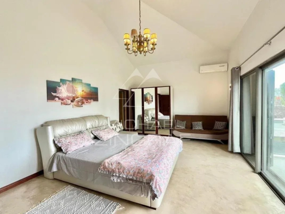 Chambre spacieuse avec lit, canapé et grandes fenêtres à Vieux Grand Port.