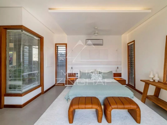 Chambre d'une villa contemporaine avec lit double et mobilier en bois à Grand Baie, Île Maurice.