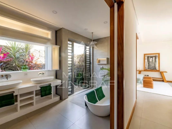 Salle de bain moderne avec baignoire et vasques, décorée de plantes, dans une villa contemporaine à Grand Baie.