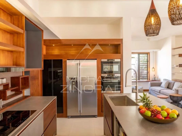 Cuisine moderne d'une villa contemporaine à Grand Baie, île Maurice, avec îlot central et espace salon.