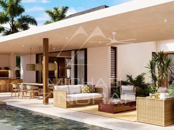 Terrasse d'une villa moderne avec piscine, meubles en rotin et plantes, à Bel Ombre.