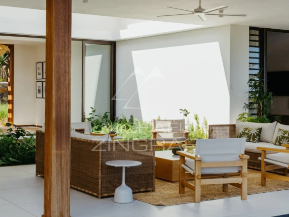 Intérieur de la Villa Vacoas à Bel Ombre, avec mobilier en osier et plantes décoratives.