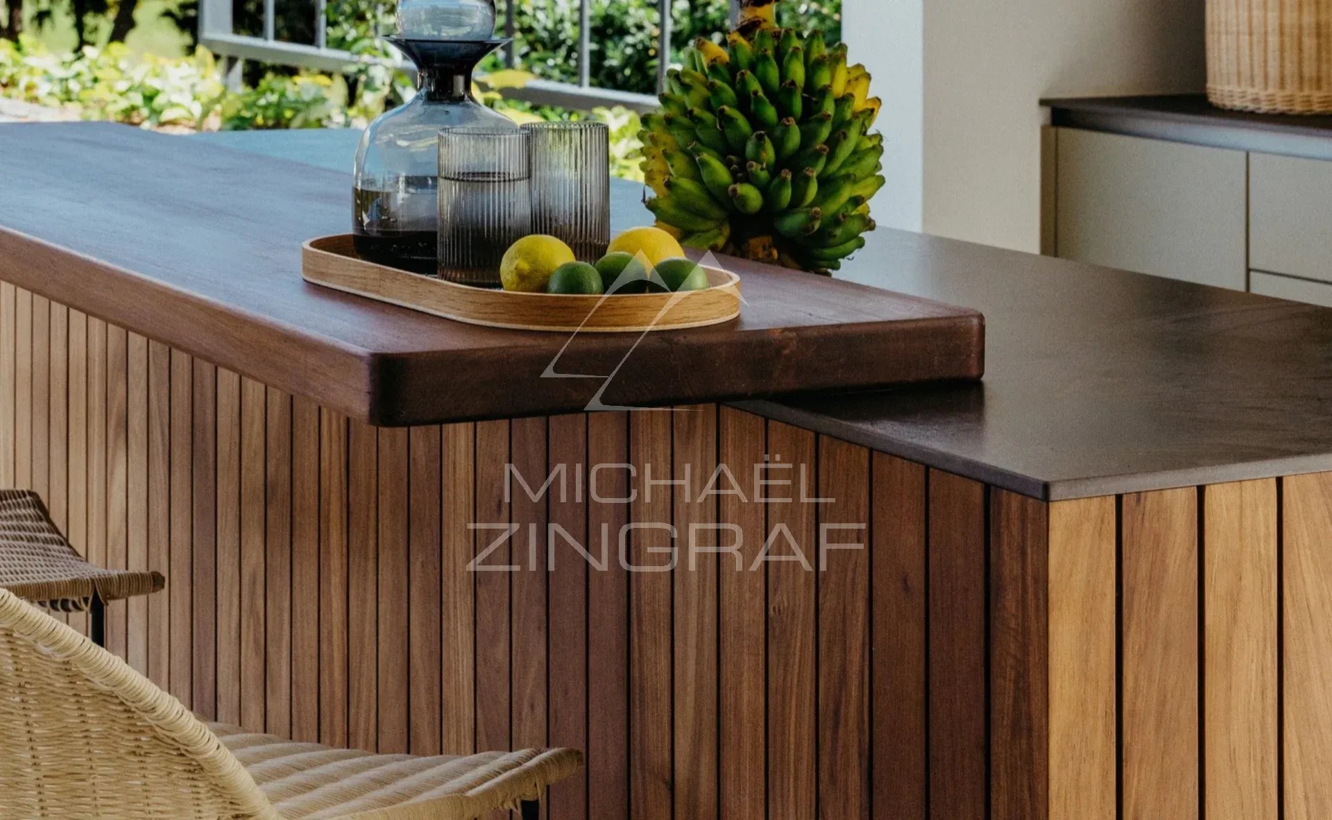 Cuisine moderne et élégante Plan de travail en bois avec des fruits et une carafe, dans un cadre élégant et naturel.