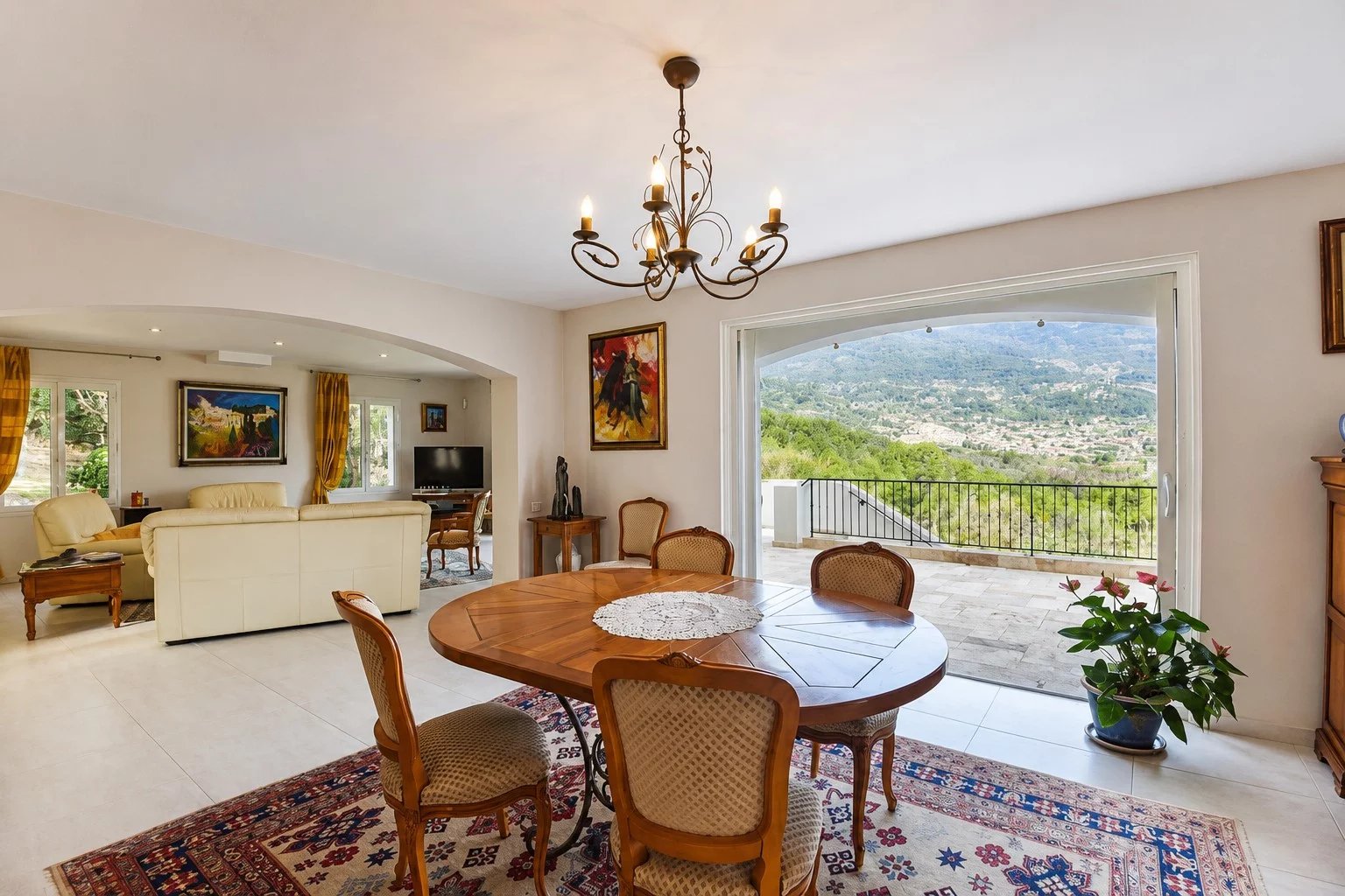 Intérieur d'une villa provençale avec une salle à manger et une vue panoramique sur la campagne.