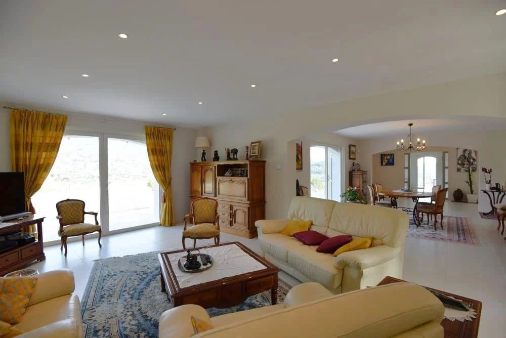 Intérieur d'une villa provençale avec salon lumineux et vue sur la campagne.