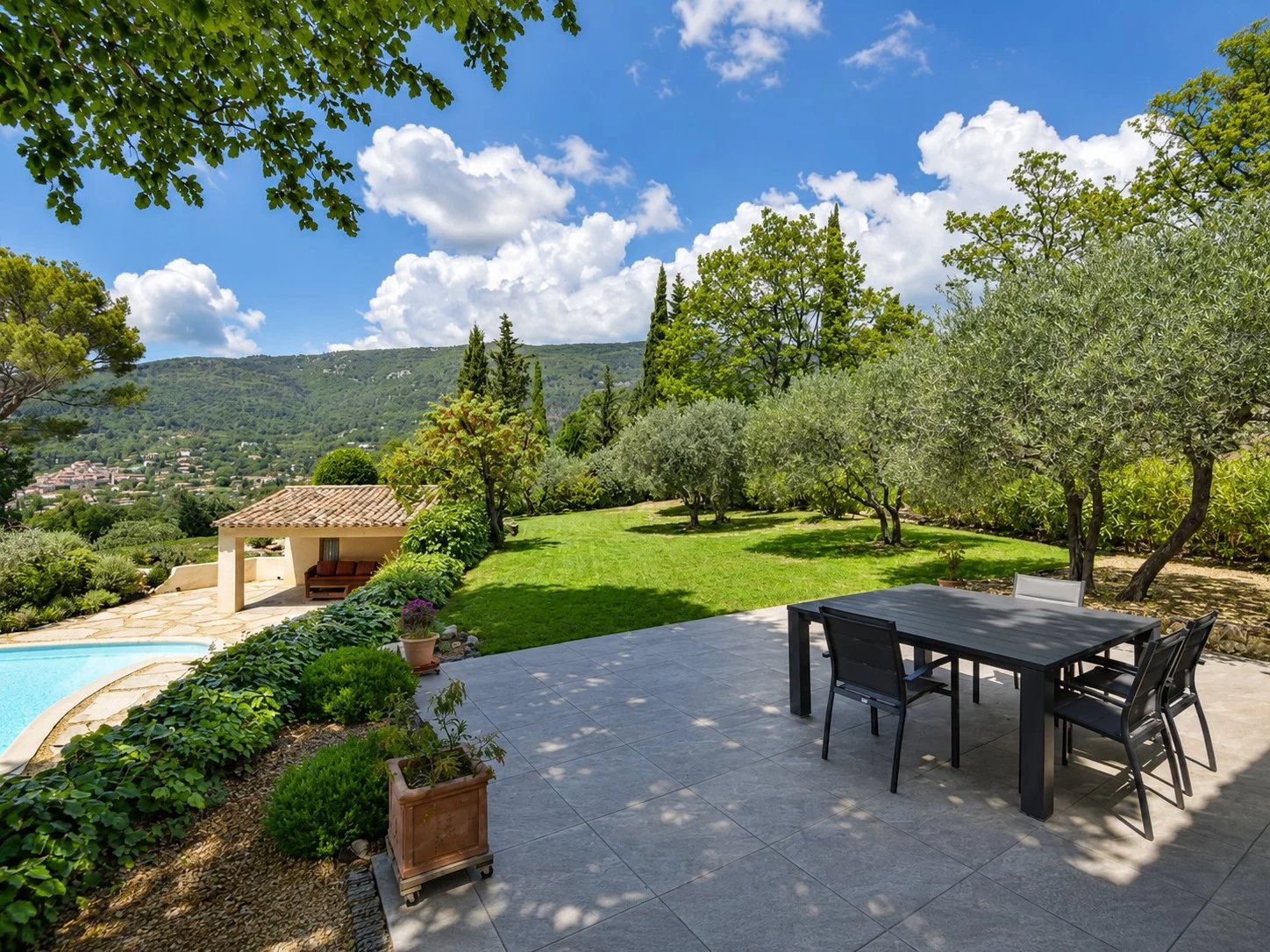 Vue d'une villa avec jardin et piscine à Seillans, entourée d'arbres et de collines.