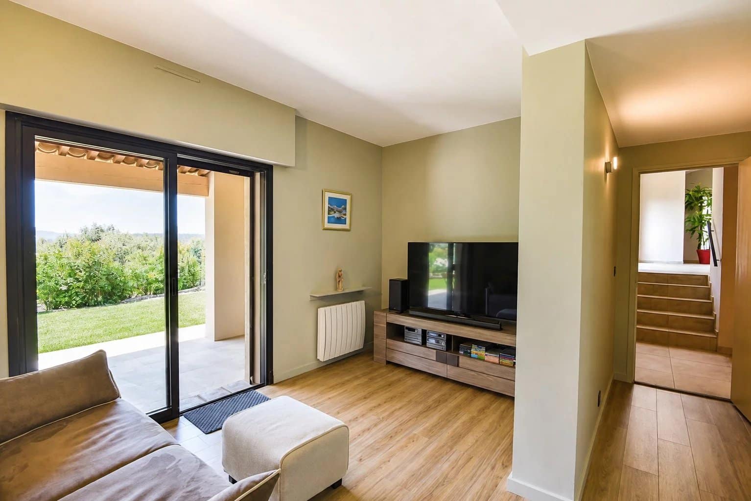 Intérieur d'une villa avec salon lumineux et accès à l'extérieur.