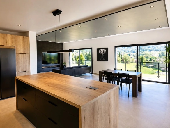 Intérieur d'une villa contemporaine avec cuisine ouverte et vue sur la nature à Fayence.
