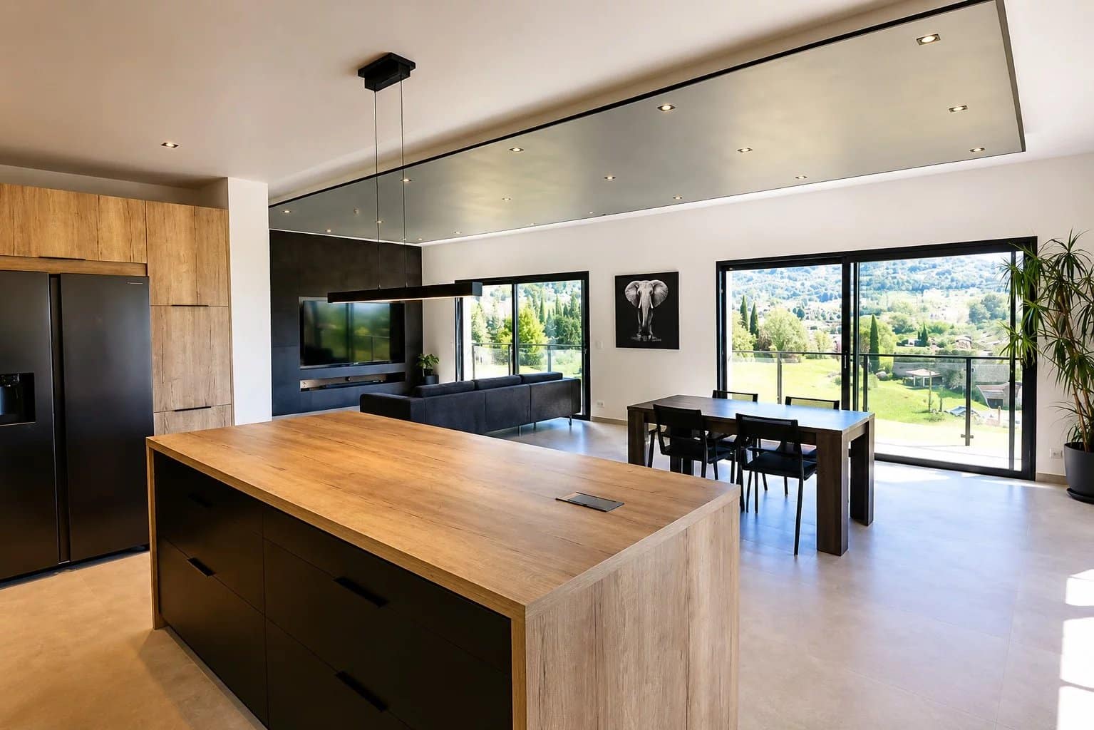 Intérieur d'une villa contemporaine avec cuisine ouverte et vue sur la nature à Fayence.