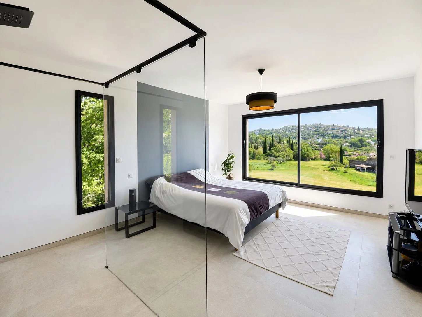 Chambre moderne avec grandes fenêtres offrant une vue sur la nature à Fayence.