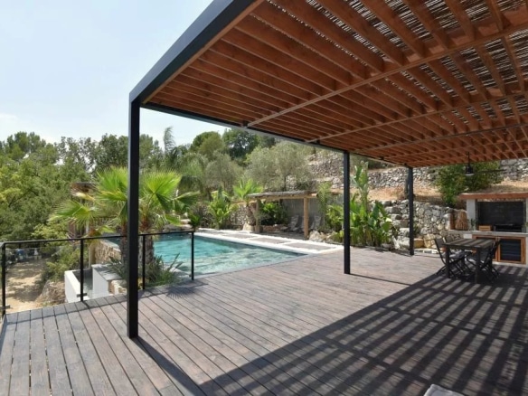 Terrasse en bois avec piscine et vue sur un jardin paysager à Fayence.