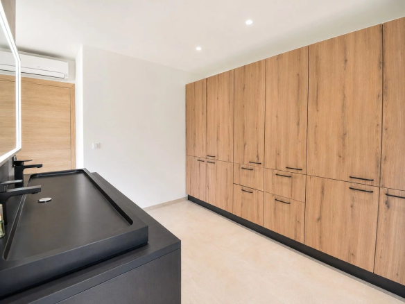 Intérieur d'une villa contemporaine avec cuisine moderne et rangements en bois.