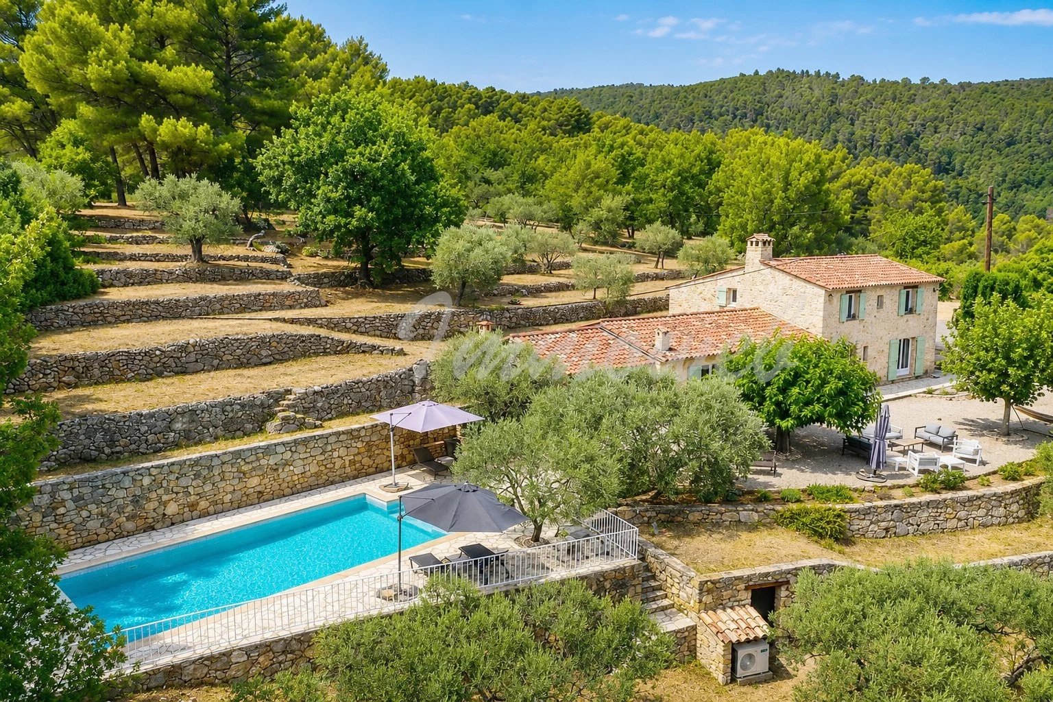 Maison en pierre avec piscine chauffée et oliveraie à Fayence, vue panoramique sur la vallée.