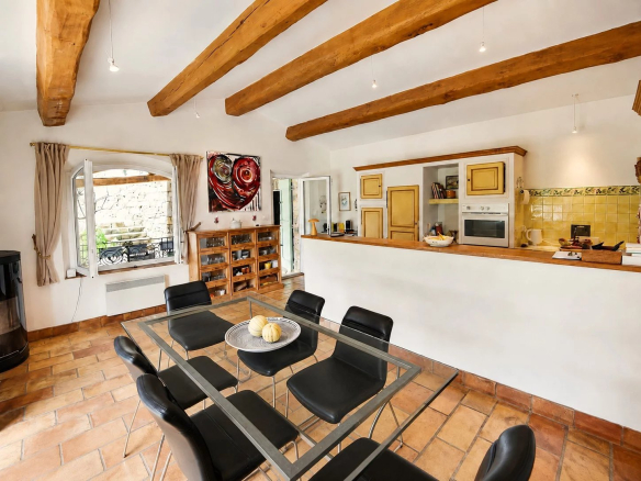 Intérieur d'une maison en pierre à Fayence avec cuisine ouverte et salle à manger.