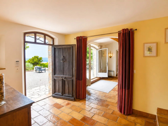 Intérieur d'une maison en pierre avec porte d'entrée en bois et vue sur l'extérieur à Fayence.